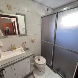 Foto de um banheiro interno com azulejos brancos e uma bancada.