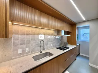 Cozinha moderna com armários de madeira e bancada clara.