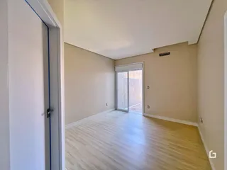 Hall de entrada com piso claro e paredes neutras.
