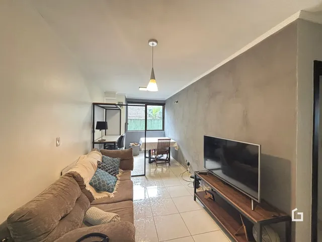 Sala de estar com sofá e área de jantar em um apartamento.