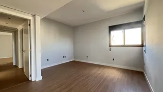 Esta é uma sala de estar com piso de madeira clara e uma janela.
