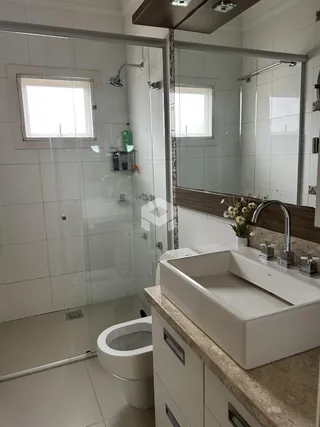 Foto de um banheiro moderno com box de vidro e pia de mármore.