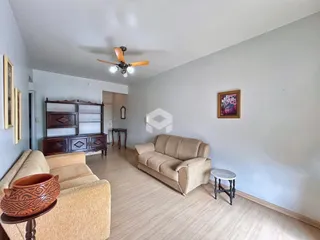 Foto da sala de estar com sofá e móveis de madeira.