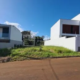Fachada de uma residência branca com vegetação no primeiro plano.