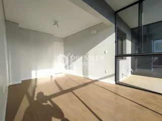 Sala de estar com piso de madeira e portas de vidro.