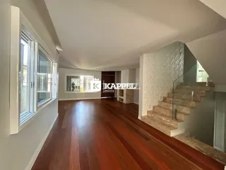 Hall de corredor com piso de madeira em uma residência.