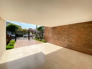Área externa com piso de cerâmica e parede de tijolos aparentes.