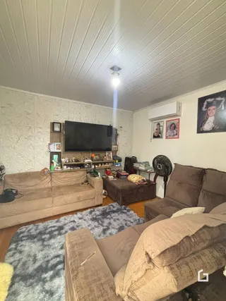 Sala de estar com sofá e televisão em ambiente interno.
