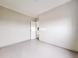Ambiente interno amplo com paredes brancas e piso claro.