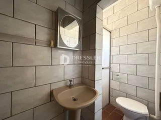 Foto de um banheiro com azulejos cinzas e pia de apoio.