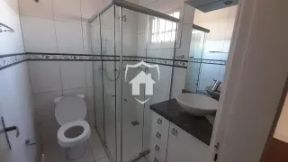Foto de um banheiro com revestimento de cerâmica e box de vidro.
