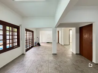 Hall de entrada com piso de cerâmica e portas de madeira.