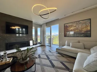 Sala de estar moderna com lareira e grandes janelas em um imóvel no Brasil.