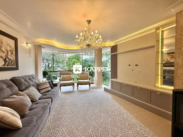 Sala de estar com sofá grande e vista para o exterior.