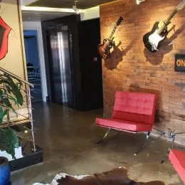 Hall de entrada com parede de tijolos aparentes e cadeira vermelha.