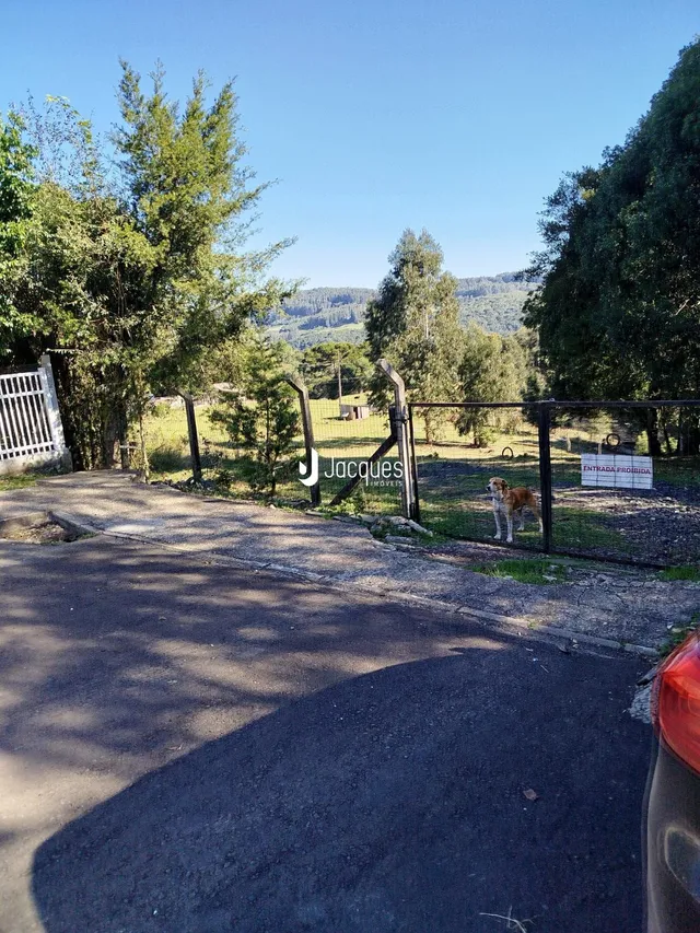 A entrada da propriedade em Lajeado, Brasil, é cercada por uma cerca de madeira e vegetação.