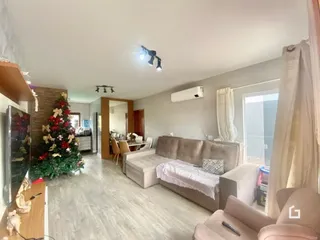 Sala de estar com sofá e piso de madeira clara.