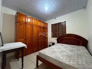 Quarto com armário de madeira e cama.