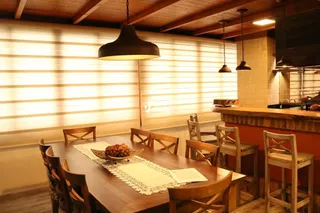Uma mesa de madeira com cadeiras em um ambiente interno.