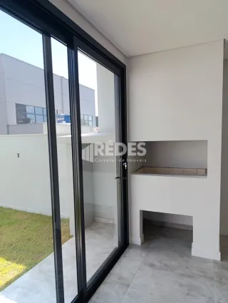Vista de uma área interna com portas de vidro que dão acesso ao exterior.