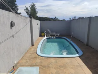 Foto de uma piscina externa em um pátio cercado por paredes brancas.