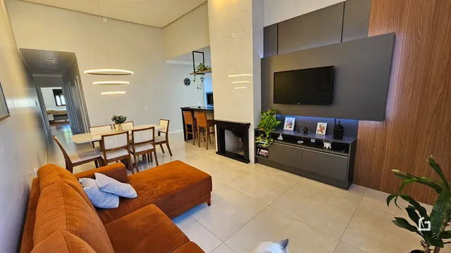 Sala de estar e jantar com lareira em um apartamento em Lajeado.