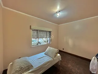 Quarto com cama e janela em ambiente interno.