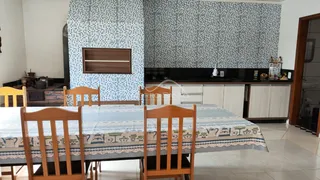 Mesa de jantar de madeira com cadeiras em um ambiente interno com parede decorada.