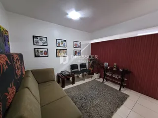 A sala de estar mostra um sofá e decoração nas paredes de uma residência.