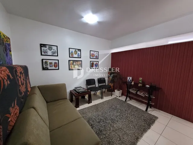 A sala de estar mostra um sofá e decoração nas paredes de uma residência.