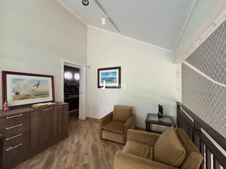 Foto de uma sala de estar com piso de madeira e móveis.