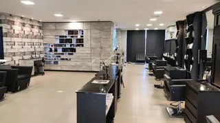 Interior de um espaço comercial moderno com estantes e mesas de trabalho.