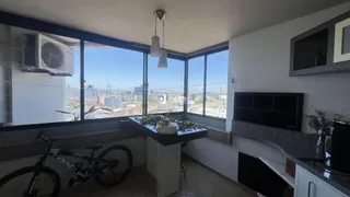 Sala de estar com grandes janelas que oferecem vista da cidade.