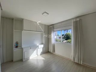 Foto de uma cozinha moderna com armários brancos e piso de madeira clara.