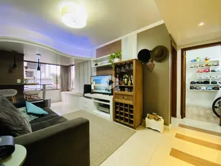 Sala de estar com decoração moderna e móveis de madeira clara.
