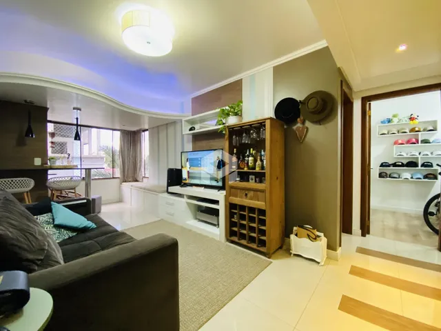 Sala de estar com decoração moderna e móveis de madeira clara.