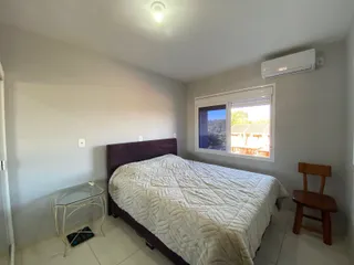 Quarto com cama grande e janela mostrando a vista externa.