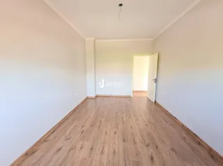 Corredor interno com piso de madeira clara.