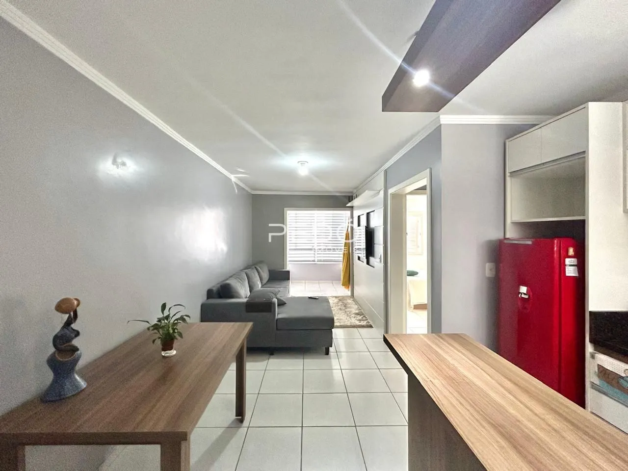 Sala de estar moderna com piso de cerâmica clara e paredes cinzas.