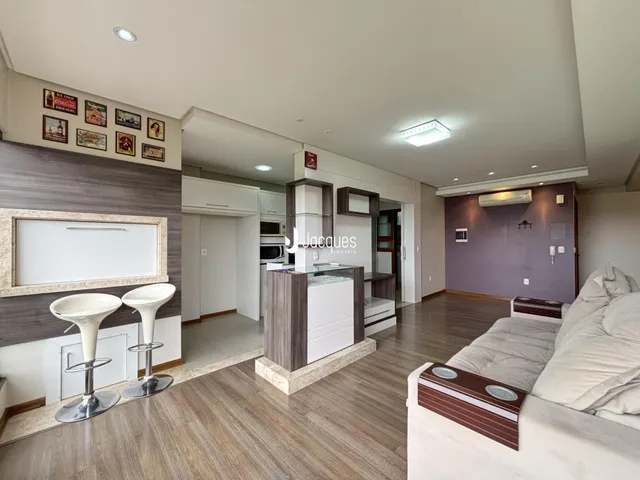 Ambiente moderno de sala de estar com cozinha integrada em Lajeado.