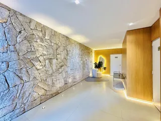 Parede de pedra rústica e piso claro em um ambiente interno.