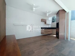 Foto da sala de estar com piso de madeira e parede texturizada.