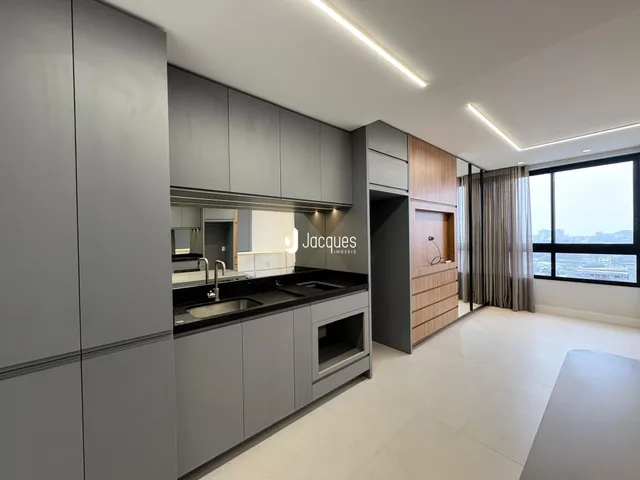Vista da cozinha moderna com armários cinzas e bancada escura.