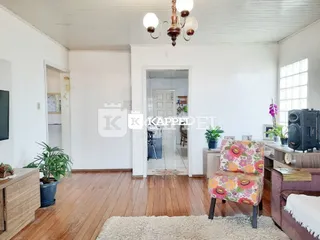 Sala de estar com piso de madeira clara e paredes brancas.