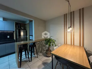 Vista de um ambiente interno com bancada e mesa de madeira.