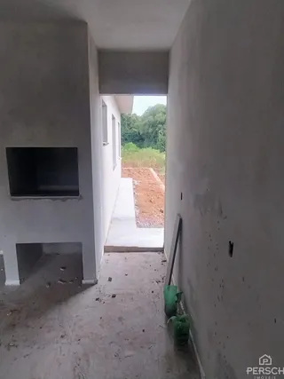 Vista de um corredor interno com acesso ao exterior em uma propriedade.
