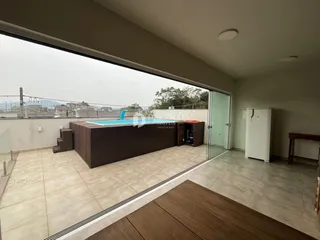Vista da sala de estar com acesso a uma área externa com piscina e deck.
