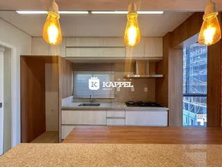 Foto da cozinha mostrando armários e bancada com vista para a cidade.