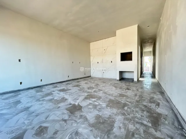 Hall amplo com piso de concreto polido e paredes brancas.
