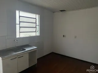 Vista interna de um cômodo com janela e bancada de pia em um imóvel.